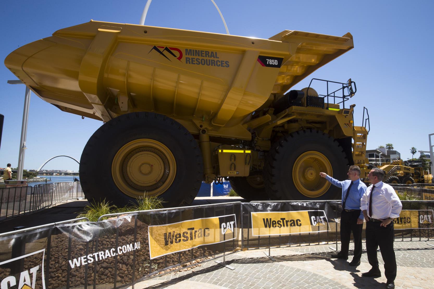 Two men standing beside a large mining truck