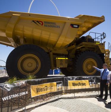 Two men standing beside a large mining truck