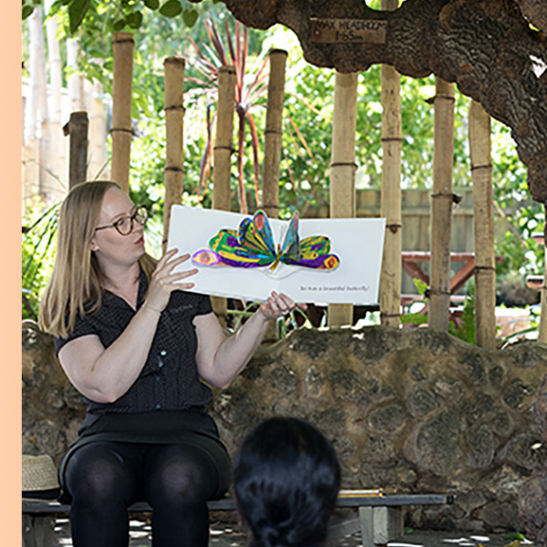 Library presenter reading picture book to audience outside. WA Tree Festival logo included.