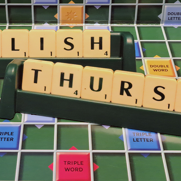 English Thursday written in Scrabble tiles on a Scrabble board