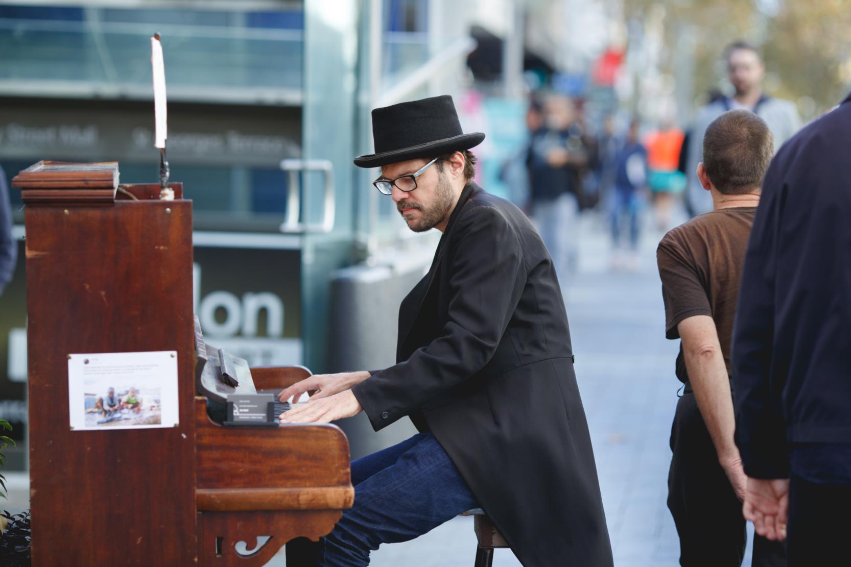 A pianist busks in the city streets