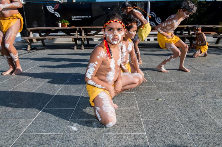 A young boy with face paint performs in Yagan Square.