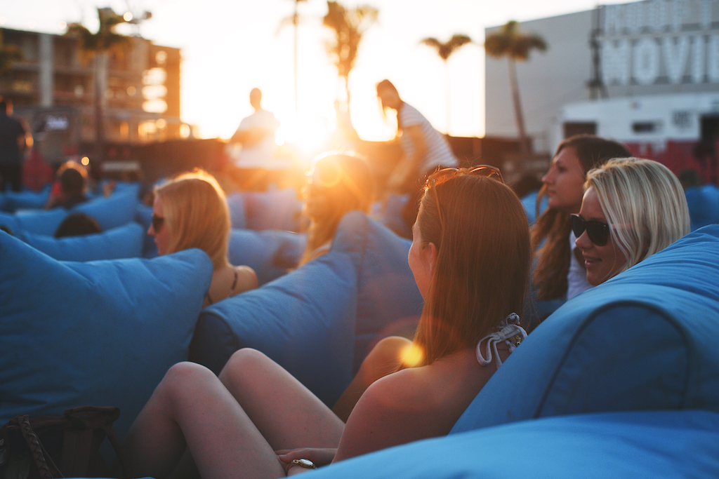 People watching a rooftop movie with sunset in background