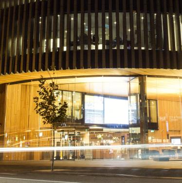 Night shot of Perth City Library with passing cars