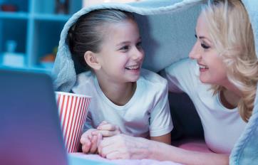 Mother and daughter watching movie on laptop at home