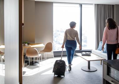 Two ladies with luggage arriving at hotel room