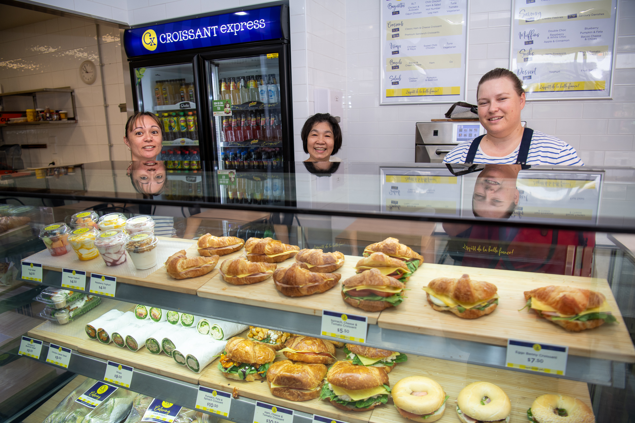 Three ladies standing behind the counter at Croissant Express