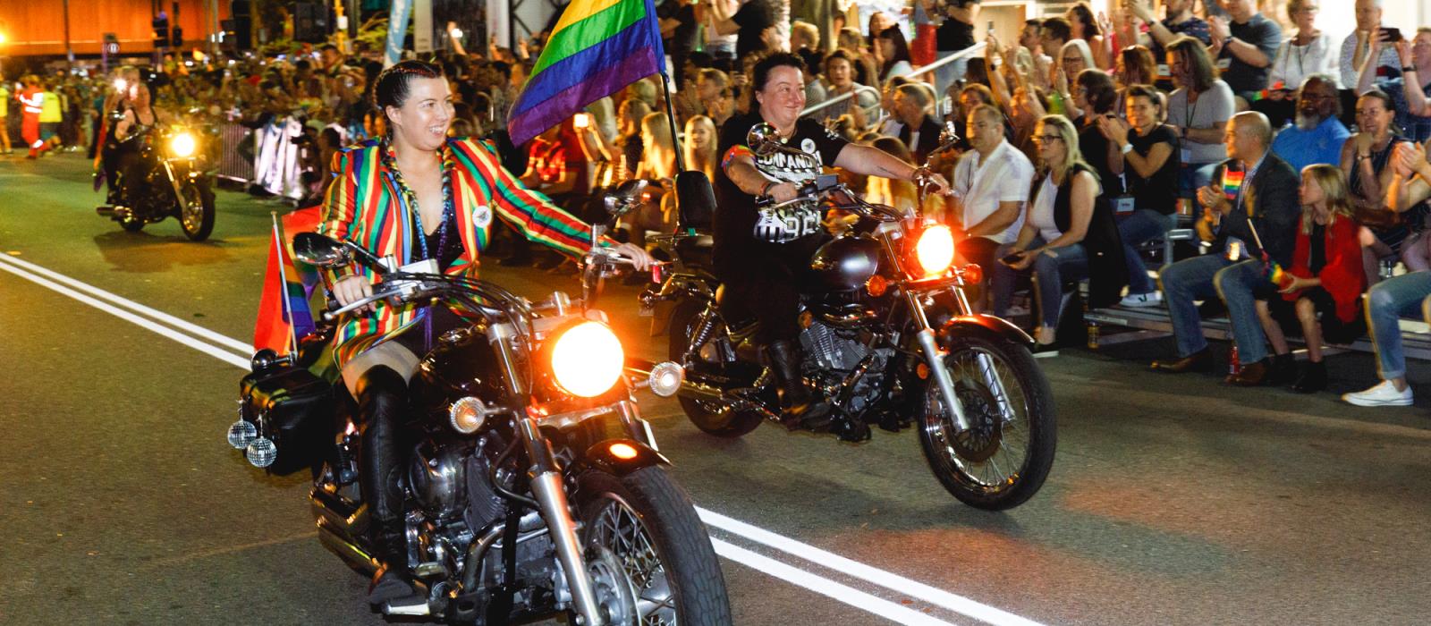 Dikes on Bikes opening Pride Parade on motorcycles with a Pride flag