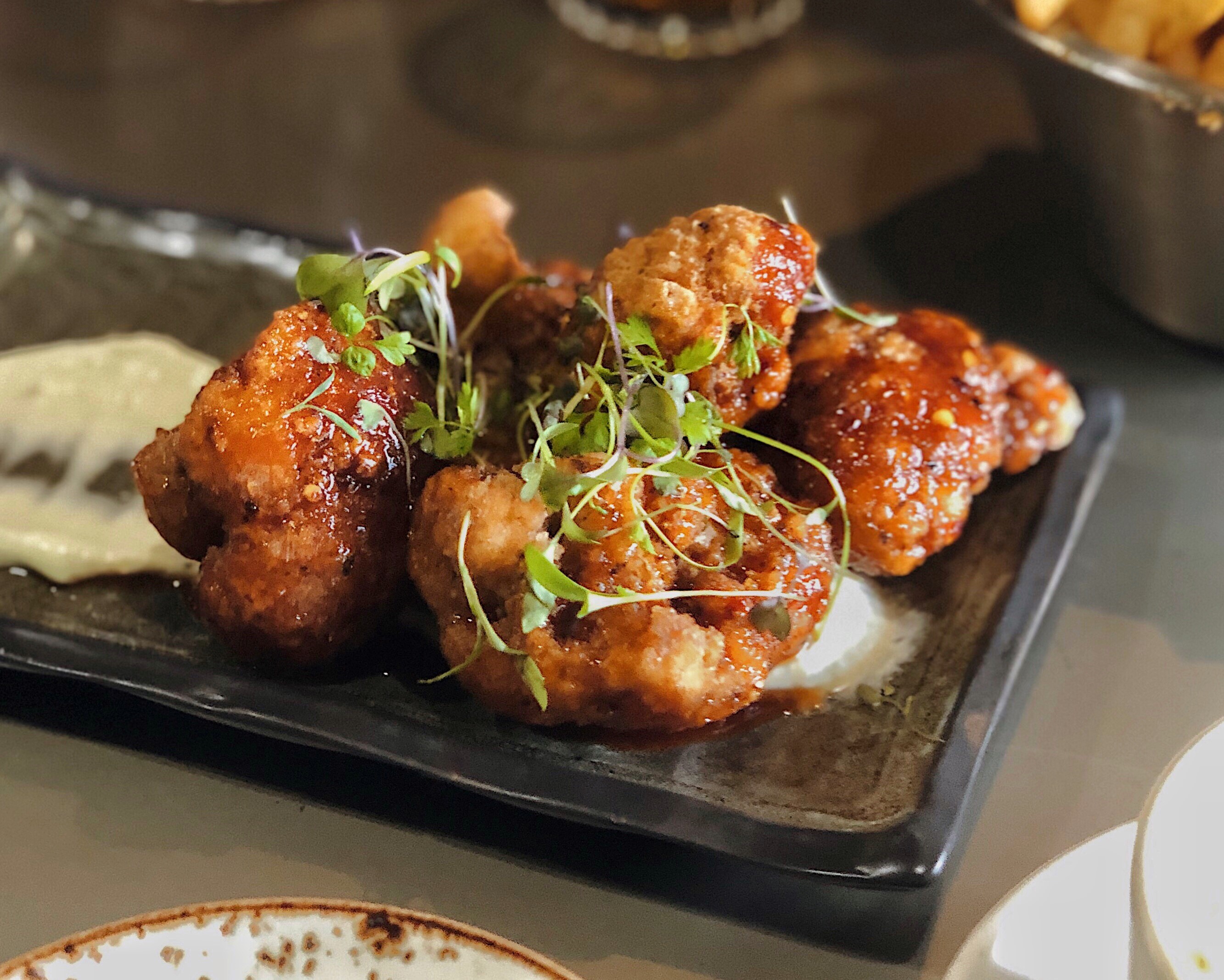 Black plate with sweet spicy fried cauliflower