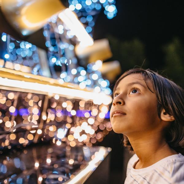 Child looking at Christmas Lights Trail installation 2023